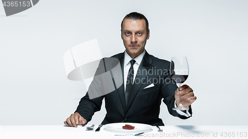 Image of Bloody Halloween theme: crazy man with a knife, fork and meat
