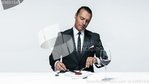 Image of Bloody Halloween theme: crazy man with a knife, fork and meat