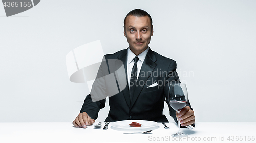 Image of Bloody Halloween theme: crazy man with a knife, fork and meat