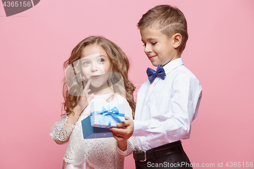 Image of Boy and girl standing in studio on pink background