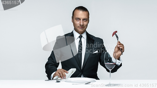 Image of Bloody Halloween theme: crazy man with a knife, fork and meat