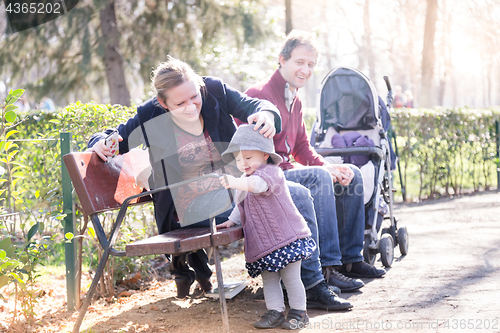 Image of Young family with cheerful child in the park.