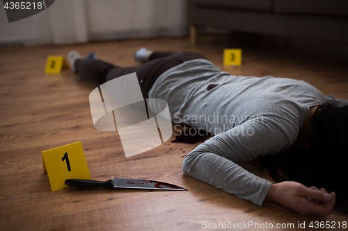 Image of dead woman body lying on floor at crime scene