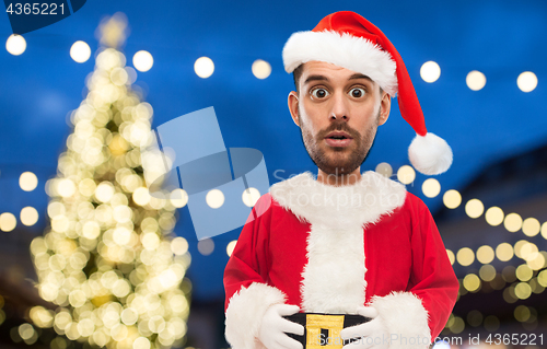 Image of man in santa claus costume over christmas lights