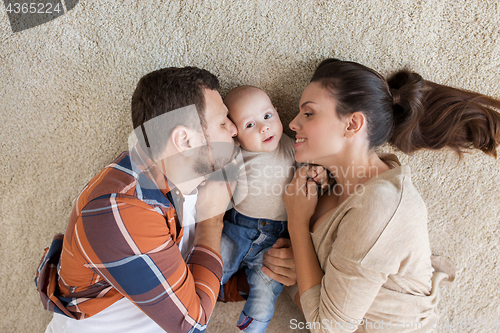 Image of happy family with baby lying on floor at home