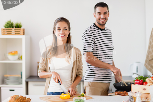 Image of couple cooking food at home kitchen