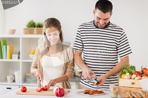 Image of happy couple cooking food at home kitchen