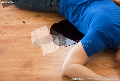 Image of dead man body in blood on floor at crime scene