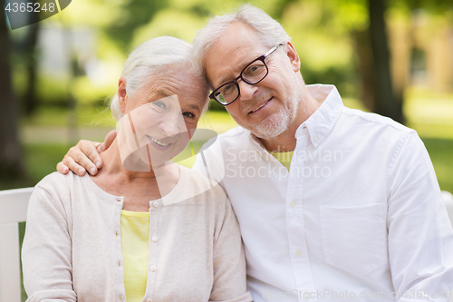 Image of happy senior couple sitting on bench at park