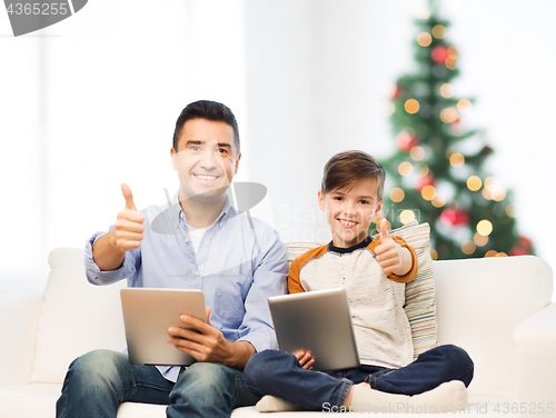 Image of father and son with tablet pc showing thumbs up