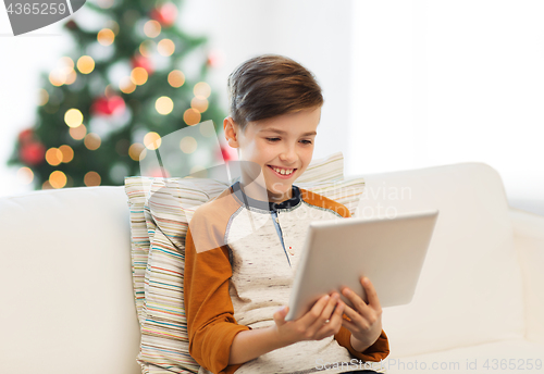 Image of smiling boy with tablet pc at home at christmas