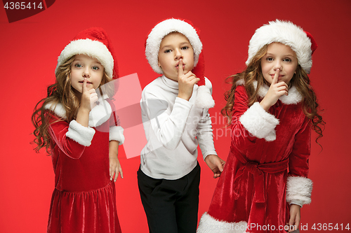 Image of The happy boy and girls in santa claus hats with gift boxes at studio