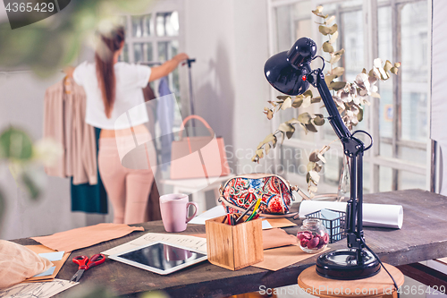 Image of Fashion designers working in studio sitting on the desk