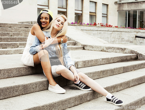 Image of Two teenage girls infront of university building smiling, having