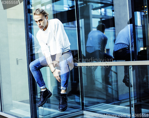 Image of young modern hipster guy at new building university blond fashio