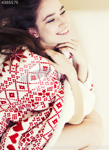 Image of young pretty brunette girl in Christmas ornament blanket getting