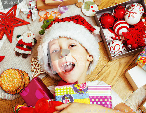 Image of little cute boy with Christmas gifts at home. close up emotional