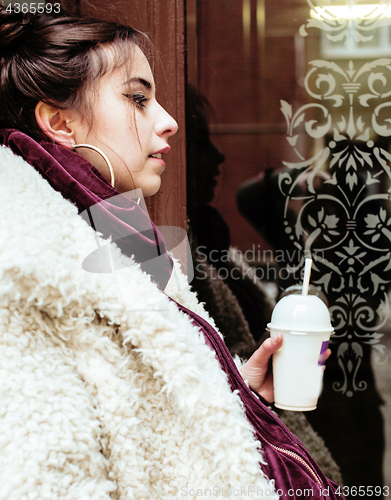 Image of young pretty stylish teenage girl outside on city street fancy f