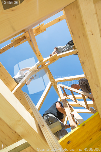 Image of Builders at work with wooden roof construction.