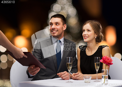 Image of couple taking menu at christmas restaurant