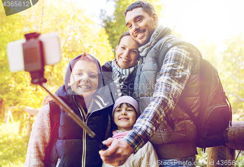 Image of family with backpacks taking selfie and hiking