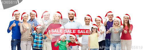 Image of people in santa hats with sale sign at christmas