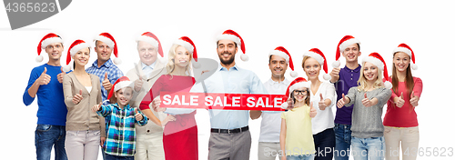 Image of people in santa hats with sale sign at christmas