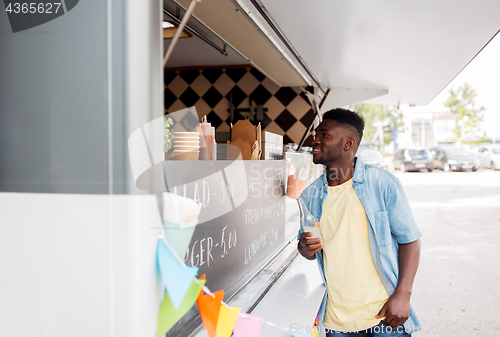 Image of african american man with drink at food truck