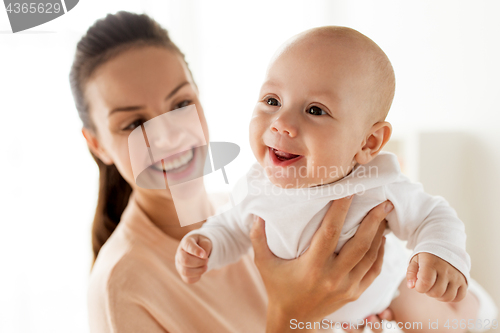 Image of happy mother playing with little baby boy at home