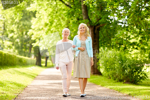 Image of daughter with senior mother walking at summer park