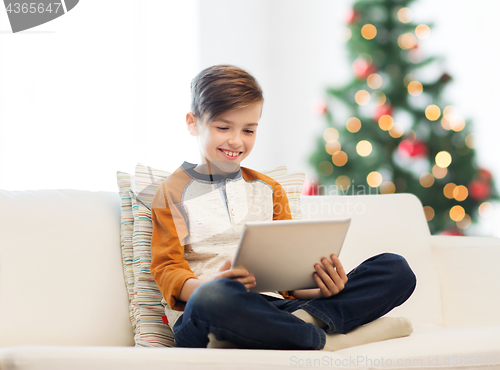 Image of smiling boy with tablet pc at home at christmas