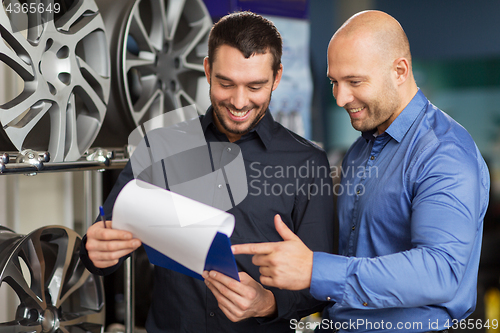 Image of customer and salesman at car service or auto store