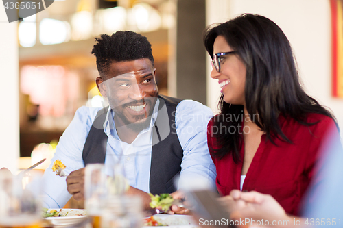 Image of happy couple eating at restaurant