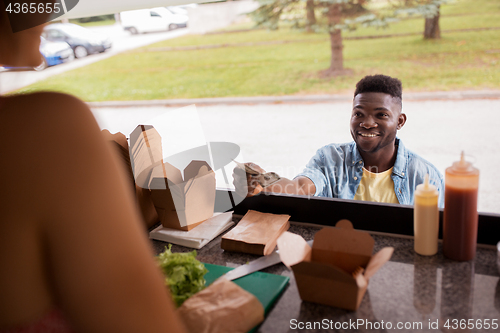 Image of african american man buying wok at food truck