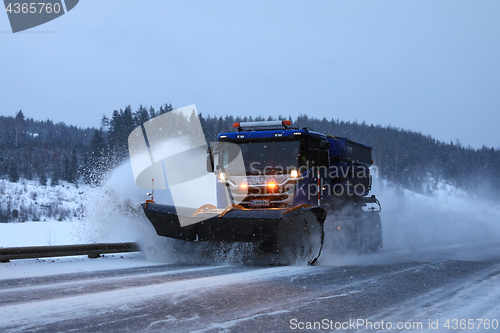 Image of Snowplow Clears Road in Evening Snowfall