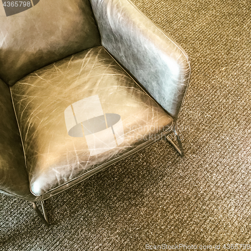 Image of Gray leather armchair on carpet floor
