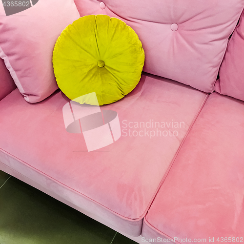 Image of Pink velvet sofa with fancy green cushion