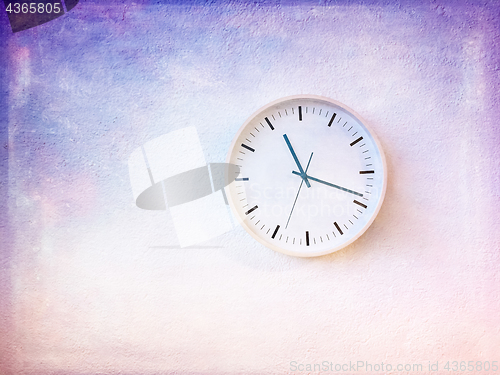 Image of Modern round clock on painted purple wall