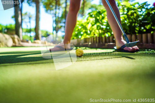 Image of Mini Golf yellow ball with a bat at sunset