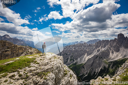 Image of Hiker woman standing up achieving the top Dolomites Alps.