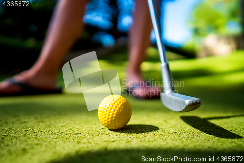 Image of Mini Golf yellow ball with a bat at sunset