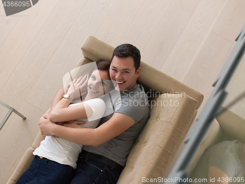 Image of young handsome couple hugging on the sofa
