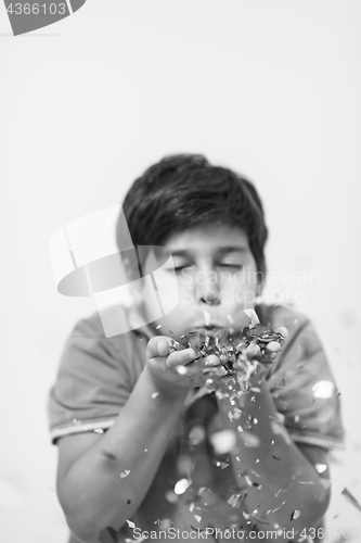 Image of kid blowing confetti