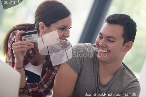 Image of happy young couple buying online