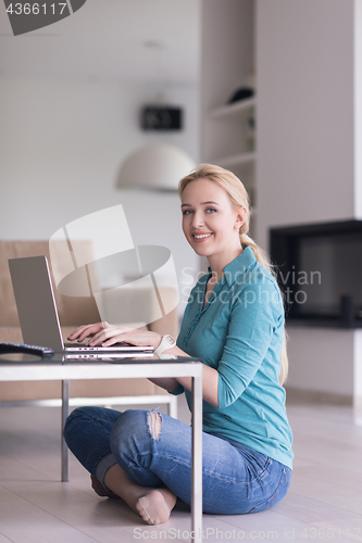 Image of young women using laptop computer on the floor