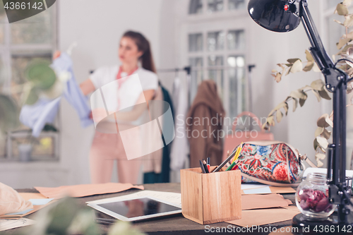 Image of Fashion designers working in studio sitting on the desk