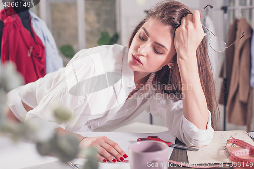 Image of Fashion designers working in studio sitting on the desk