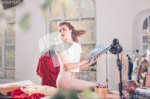 Image of Fashion designers working in studio sitting on the desk