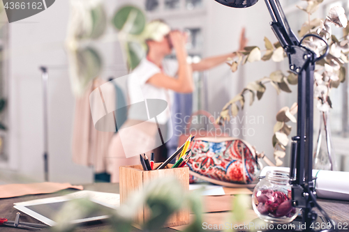 Image of Fashion designers working in studio sitting on the desk