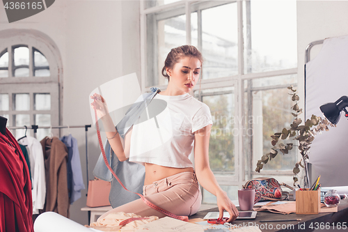 Image of Fashion designers working in studio sitting on the desk